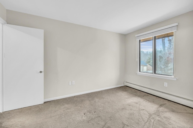 empty room with a baseboard heating unit and carpet