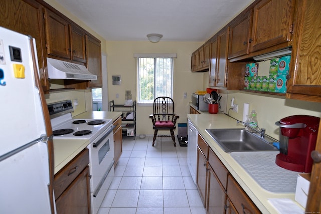 kitchen with white appliances, light tile patterned floors, and sink