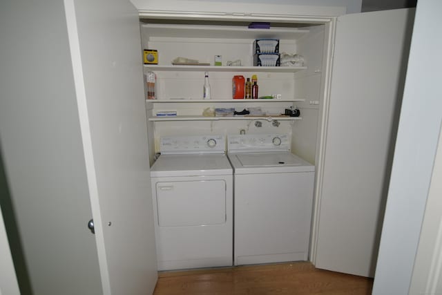 laundry area with washing machine and clothes dryer and hardwood / wood-style floors