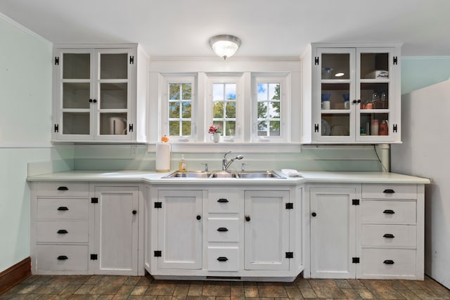 bar featuring crown molding, sink, and white cabinetry