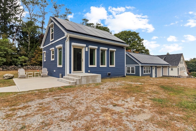 view of front of home featuring a patio and solar panels