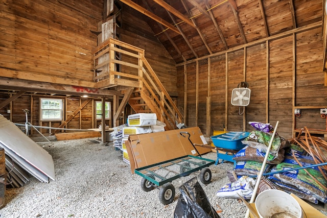 misc room with lofted ceiling, wood walls, and carpet flooring