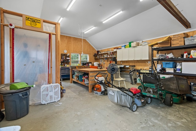 garage featuring wood walls and a workshop area