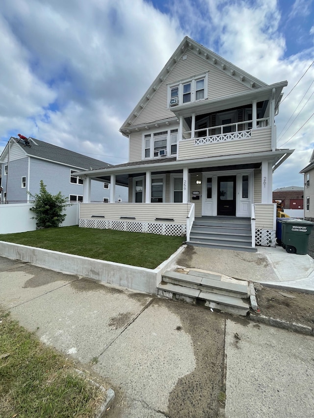 view of front of home with a front lawn, covered porch, and a balcony