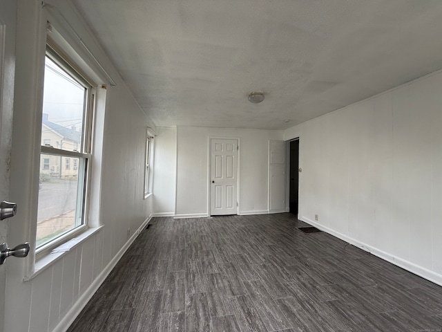 unfurnished room featuring a textured ceiling and dark hardwood / wood-style floors