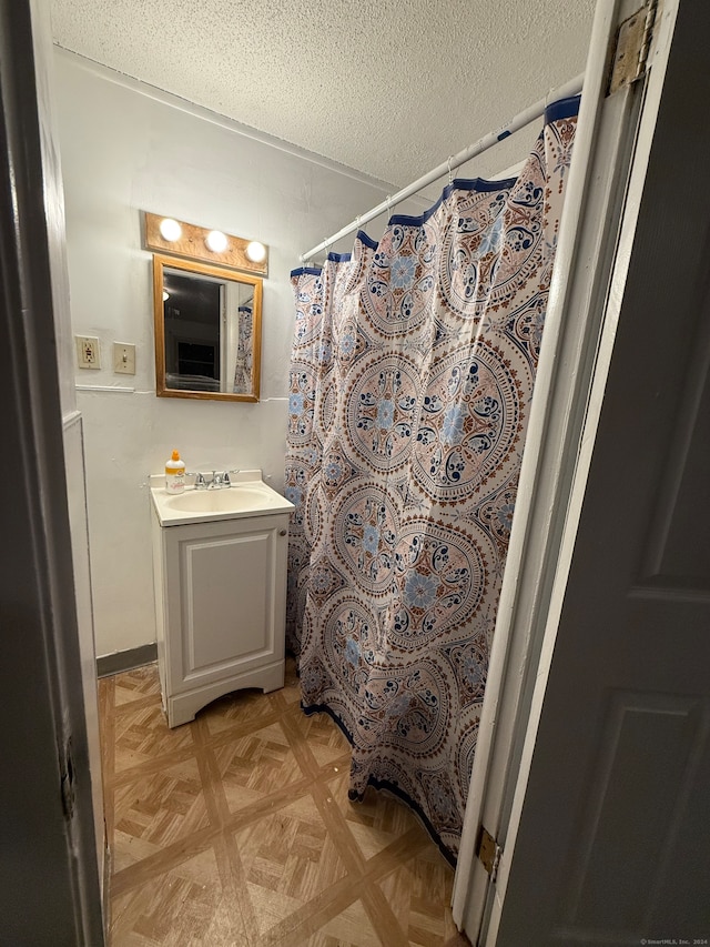 bathroom featuring walk in shower, parquet floors, and vanity