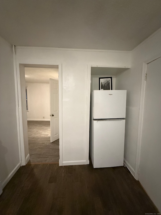 kitchen featuring ornamental molding, dark hardwood / wood-style floors, and white fridge