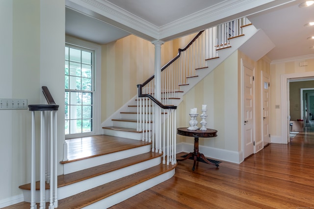 staircase with wood-type flooring, decorative columns, plenty of natural light, and ornamental molding