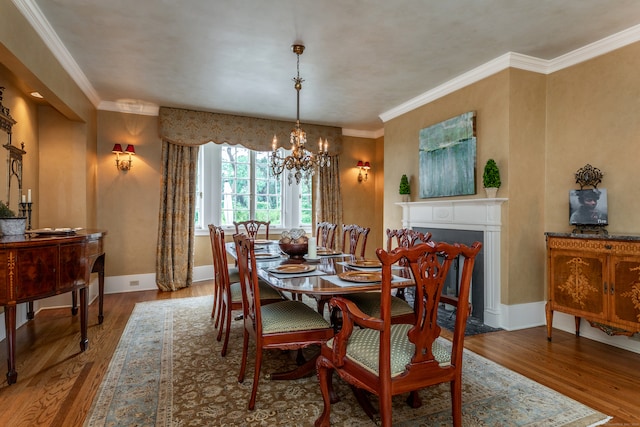 dining space with a notable chandelier, crown molding, and hardwood / wood-style flooring