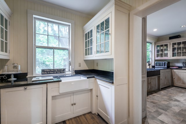 kitchen featuring ornamental molding, backsplash, sink, and white cabinets