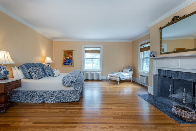 bedroom with ornamental molding, radiator, hardwood / wood-style floors, and an AC wall unit