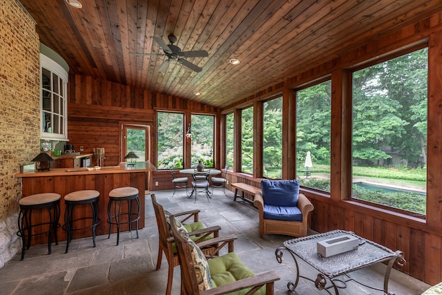 sunroom / solarium with lofted ceiling, ceiling fan, and wooden ceiling