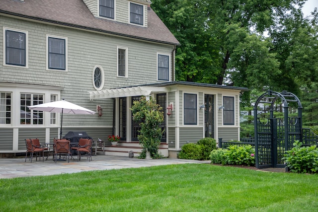 back of property featuring a lawn and a patio area