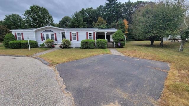 1 Circle Dr, Windham, CT 06256 - manufactured / mobile home featuring a porch, aphalt driveway, and a front lawn