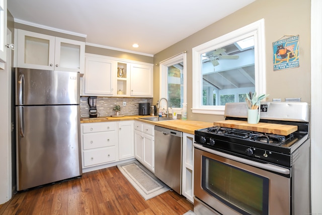 kitchen with dark wood-type flooring, sink, white cabinetry, butcher block counters, and stainless steel appliances