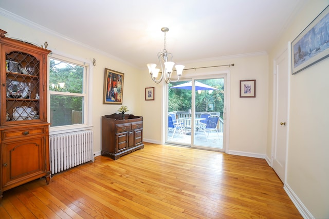 dining space featuring radiator, a notable chandelier, light wood-type flooring, and plenty of natural light