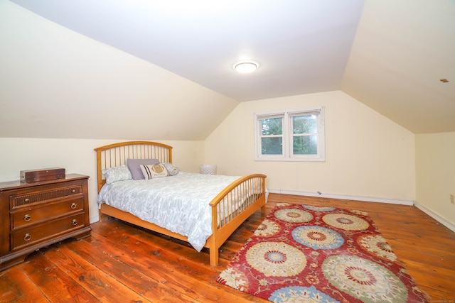 bedroom with lofted ceiling and dark wood-type flooring