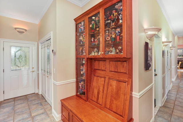 tiled foyer featuring ornamental molding