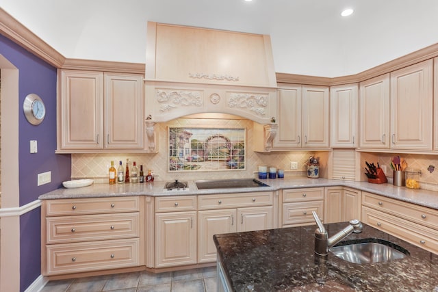 kitchen featuring stone countertops, custom range hood, and sink