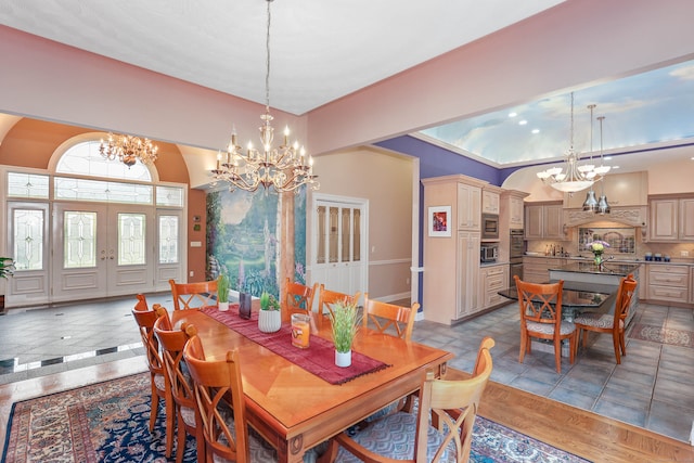 dining room with an inviting chandelier, light wood-type flooring, and vaulted ceiling