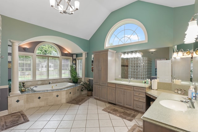 bathroom with tiled tub, high vaulted ceiling, tile patterned floors, vanity, and ornate columns