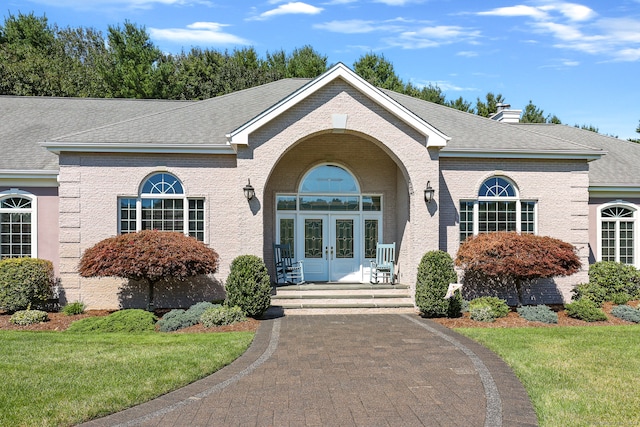 ranch-style home featuring a front lawn and french doors