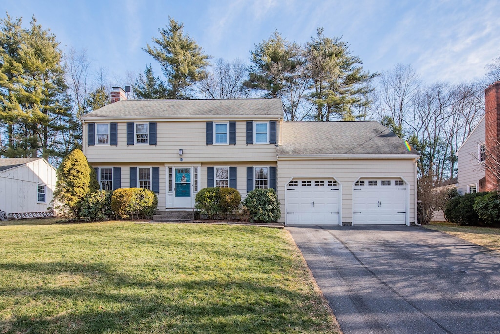 colonial home with a front yard and a garage