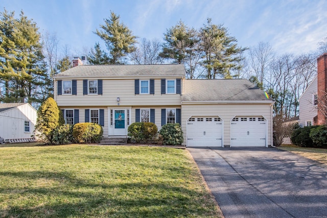 colonial home with a front yard and a garage