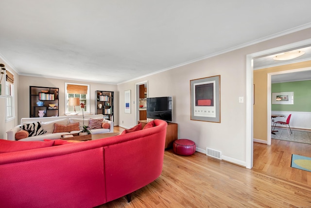 living room featuring crown molding and light hardwood / wood-style flooring