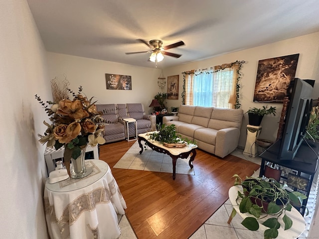 living room featuring a fireplace, light wood-type flooring, and ceiling fan