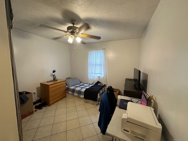 tiled bedroom featuring ceiling fan and a textured ceiling