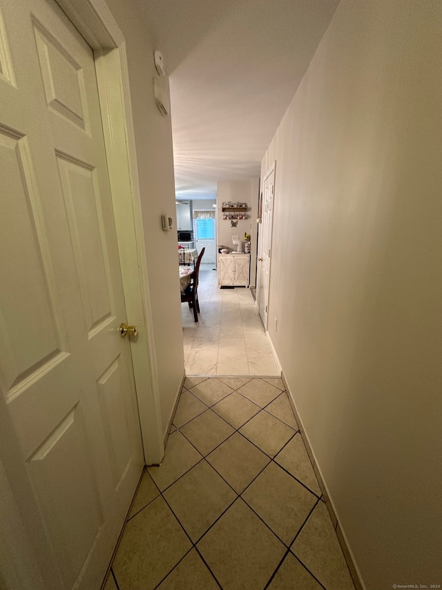 corridor featuring light tile patterned flooring