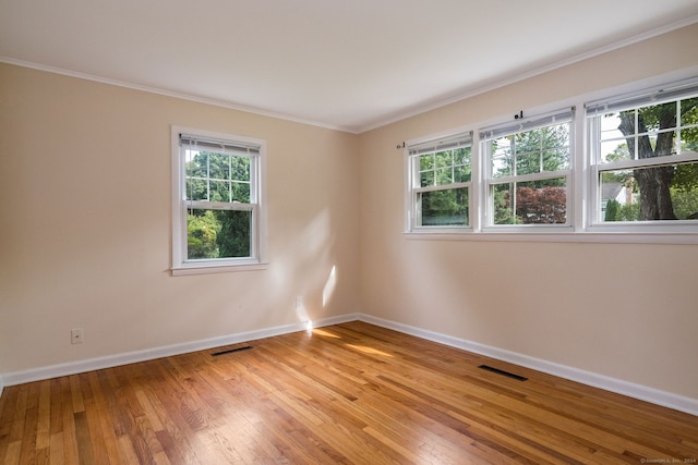 unfurnished room featuring ornamental molding and hardwood / wood-style floors