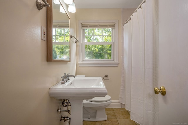 bathroom with toilet, curtained shower, and tile patterned floors