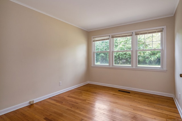 unfurnished room with crown molding, light hardwood / wood-style flooring, and plenty of natural light