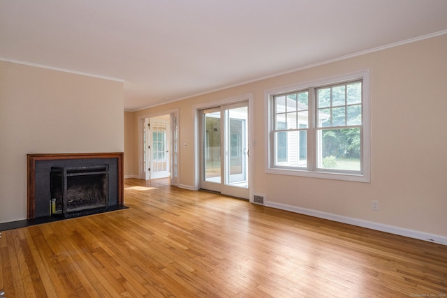 unfurnished living room with light hardwood / wood-style floors and crown molding