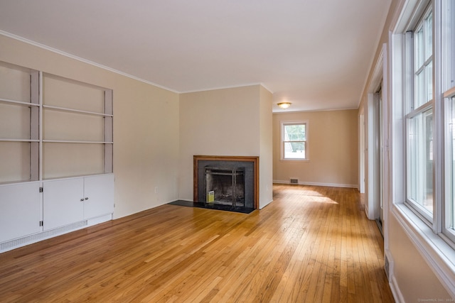 unfurnished living room featuring ornamental molding and light hardwood / wood-style flooring