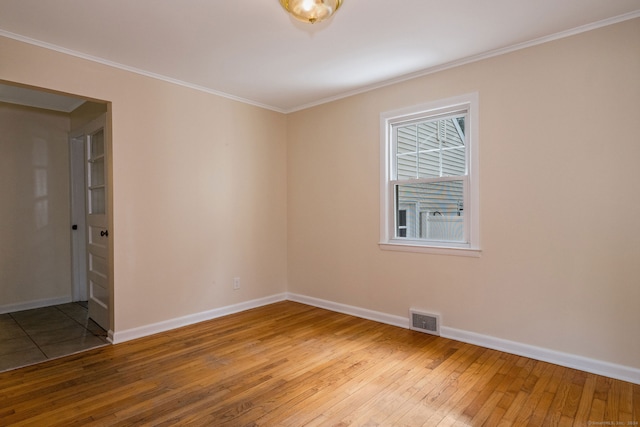 unfurnished room with ornamental molding and hardwood / wood-style flooring