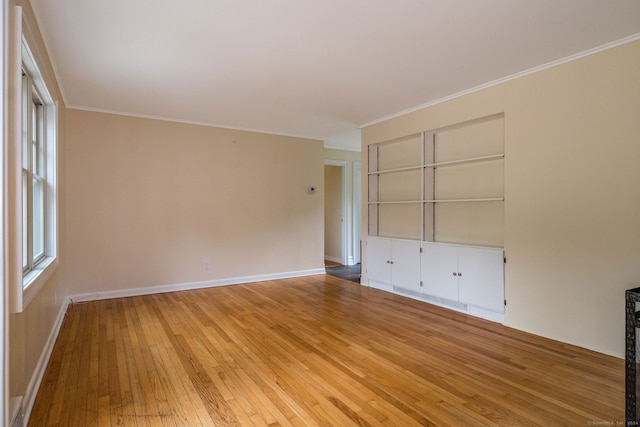 empty room featuring hardwood / wood-style flooring and ornamental molding