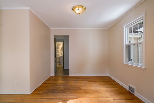 empty room with crown molding and hardwood / wood-style flooring