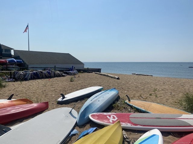 exterior space featuring a water view and a beach view