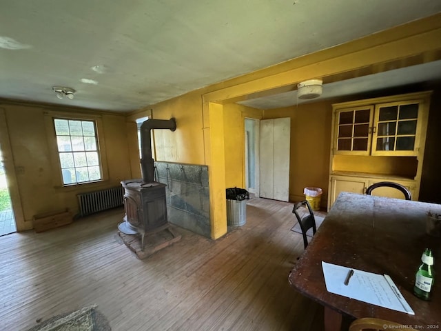 living room with a wood stove, radiator heating unit, and dark wood-type flooring