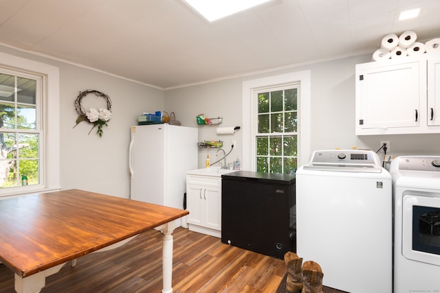 washroom featuring ornamental molding, washer and dryer, dark hardwood / wood-style floors, and cabinets