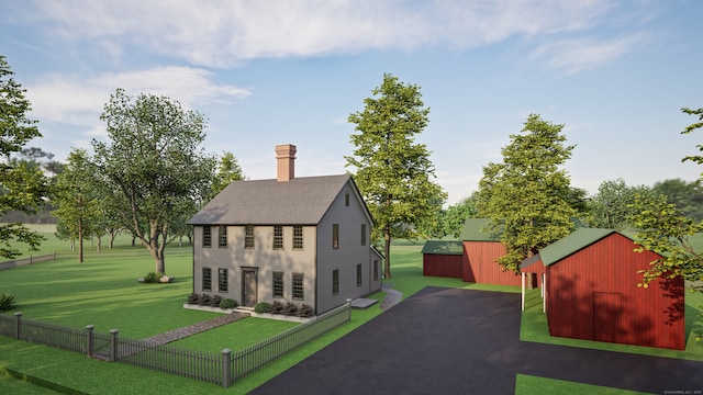 rear view of house featuring a lawn and an outdoor structure