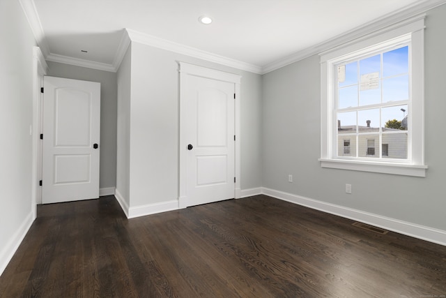 unfurnished bedroom with a closet, dark hardwood / wood-style floors, and ornamental molding