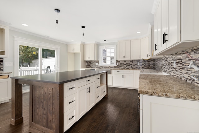 kitchen with a healthy amount of sunlight, white cabinets, and decorative light fixtures