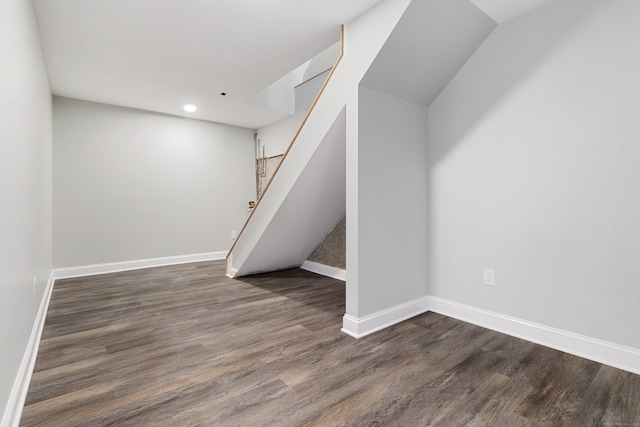 basement with dark hardwood / wood-style floors