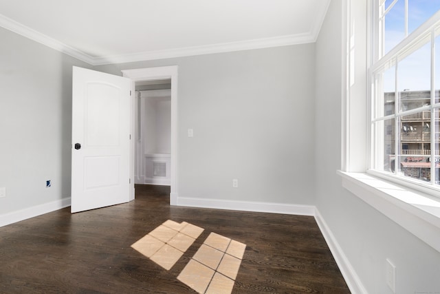 spare room featuring ornamental molding, dark hardwood / wood-style floors, and plenty of natural light