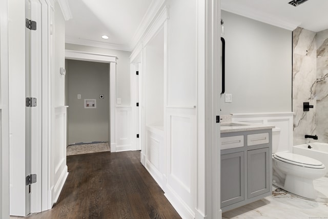 full bathroom with vanity, crown molding, tiled shower / bath combo, hardwood / wood-style flooring, and toilet