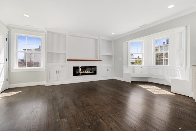 unfurnished living room with a healthy amount of sunlight, ornamental molding, and dark hardwood / wood-style floors